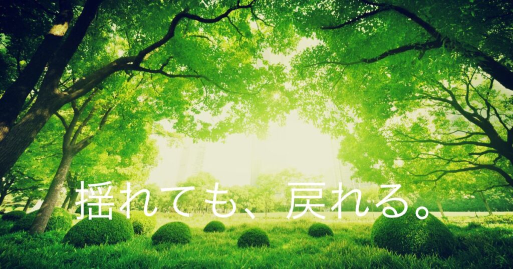 春の森の中、光が差し込む木々の風景。異動で揺れた心が軸に戻るイメージ