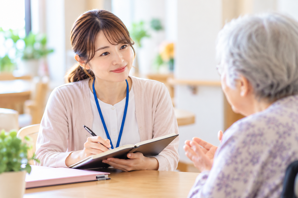 ラポール形成の一環として、施設相談員が利用者の話を聞きながらノートに記録している様子